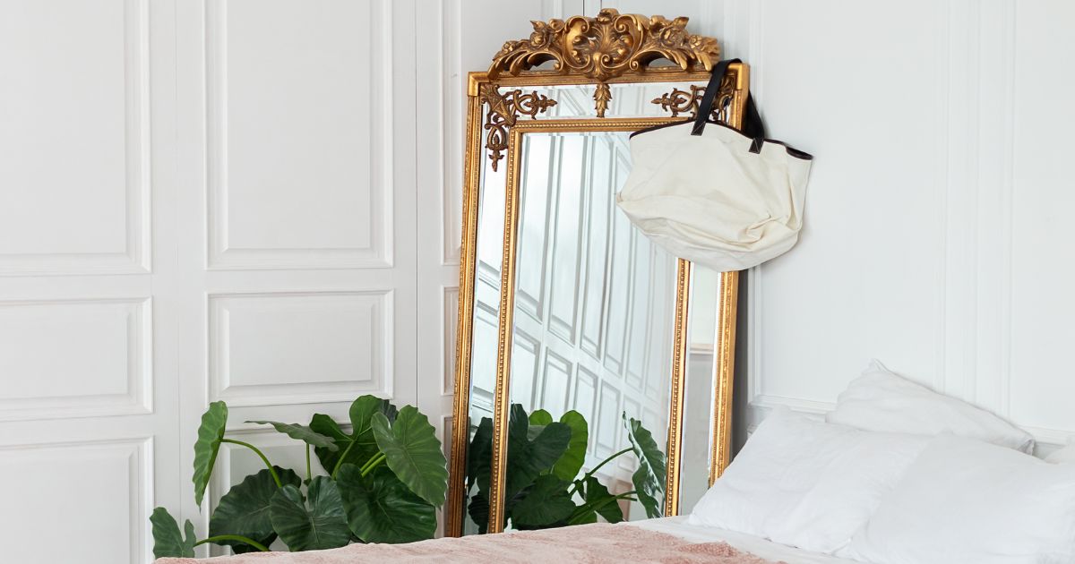 A full-length mirror sits in the corner of a bedroom and will be packed for a long distance move.