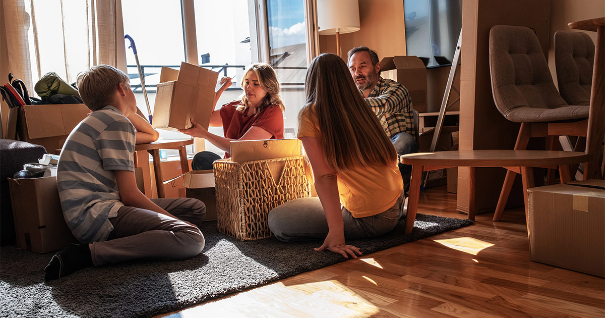 A family of four gathers in their living room to discuss how to declutter before a move they have planned.