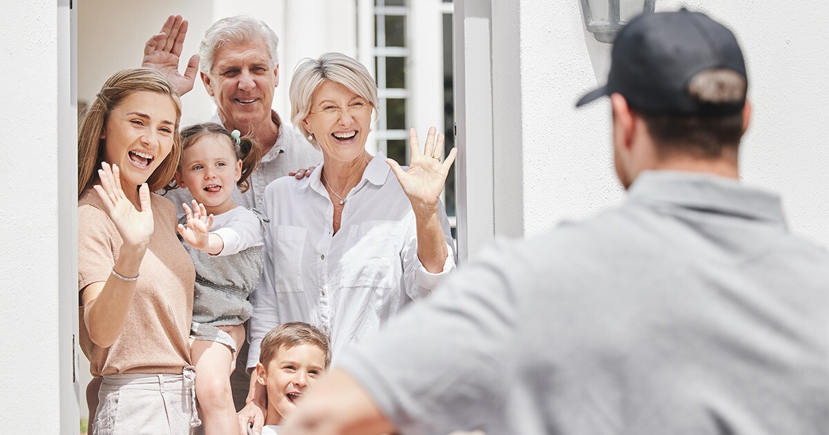 A family waves goodbye to a moving professional after a long distance move. They have just given him and his other crew members a tip.